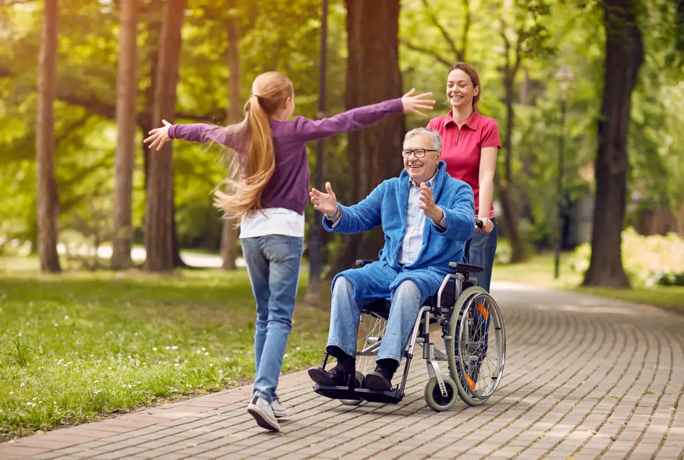 Active wheelchair user in a park with a carer