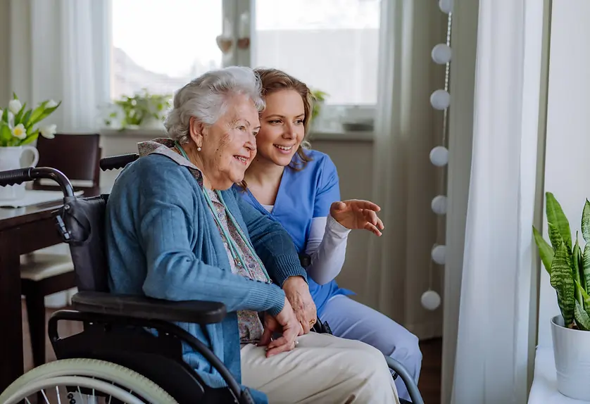 Elderly resident with a carer in a nursing home setting